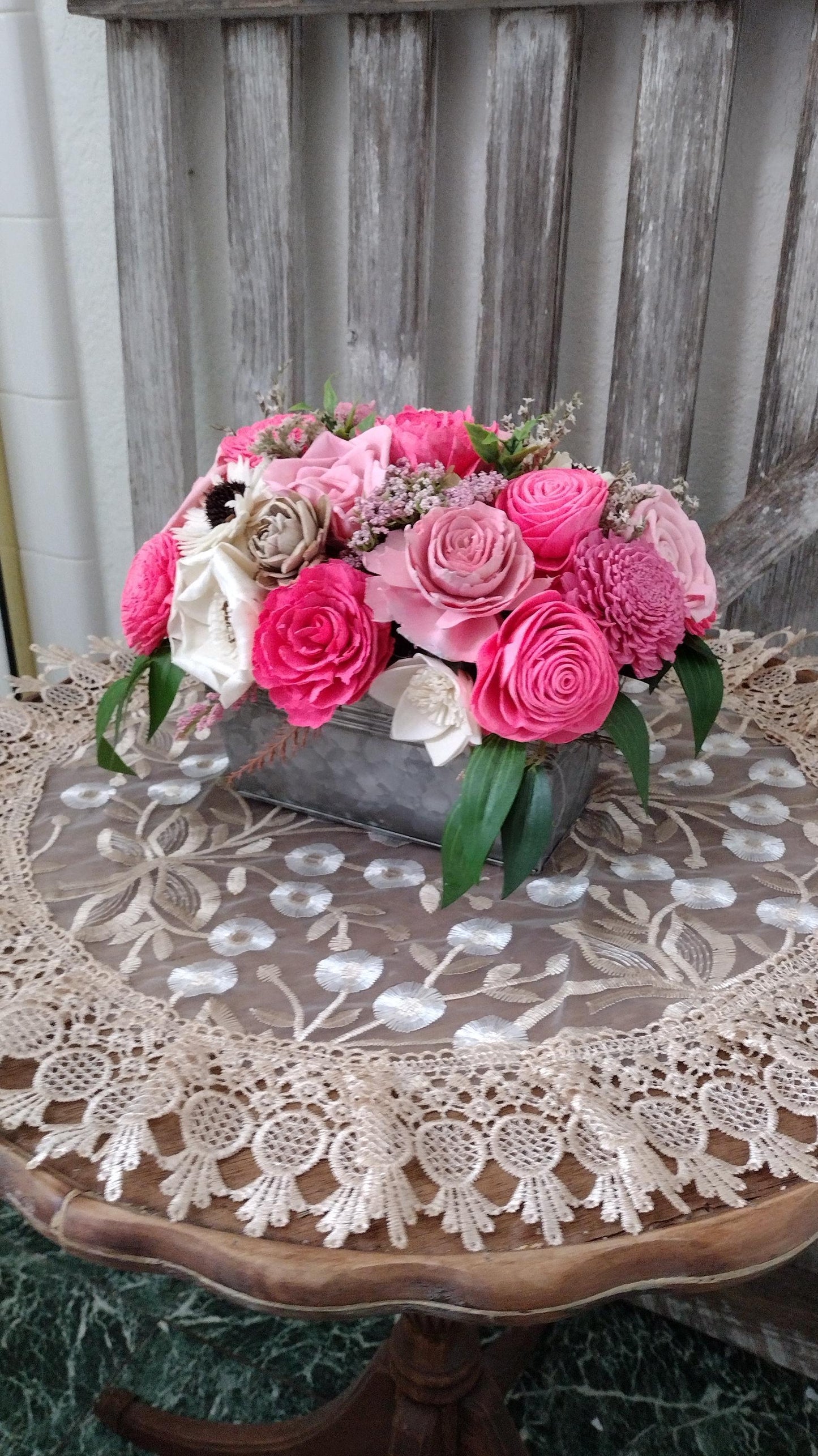 Centerpiece with hand dyed Sola flowers. Beautiful shades of pink wooden florals in a galvanized container
