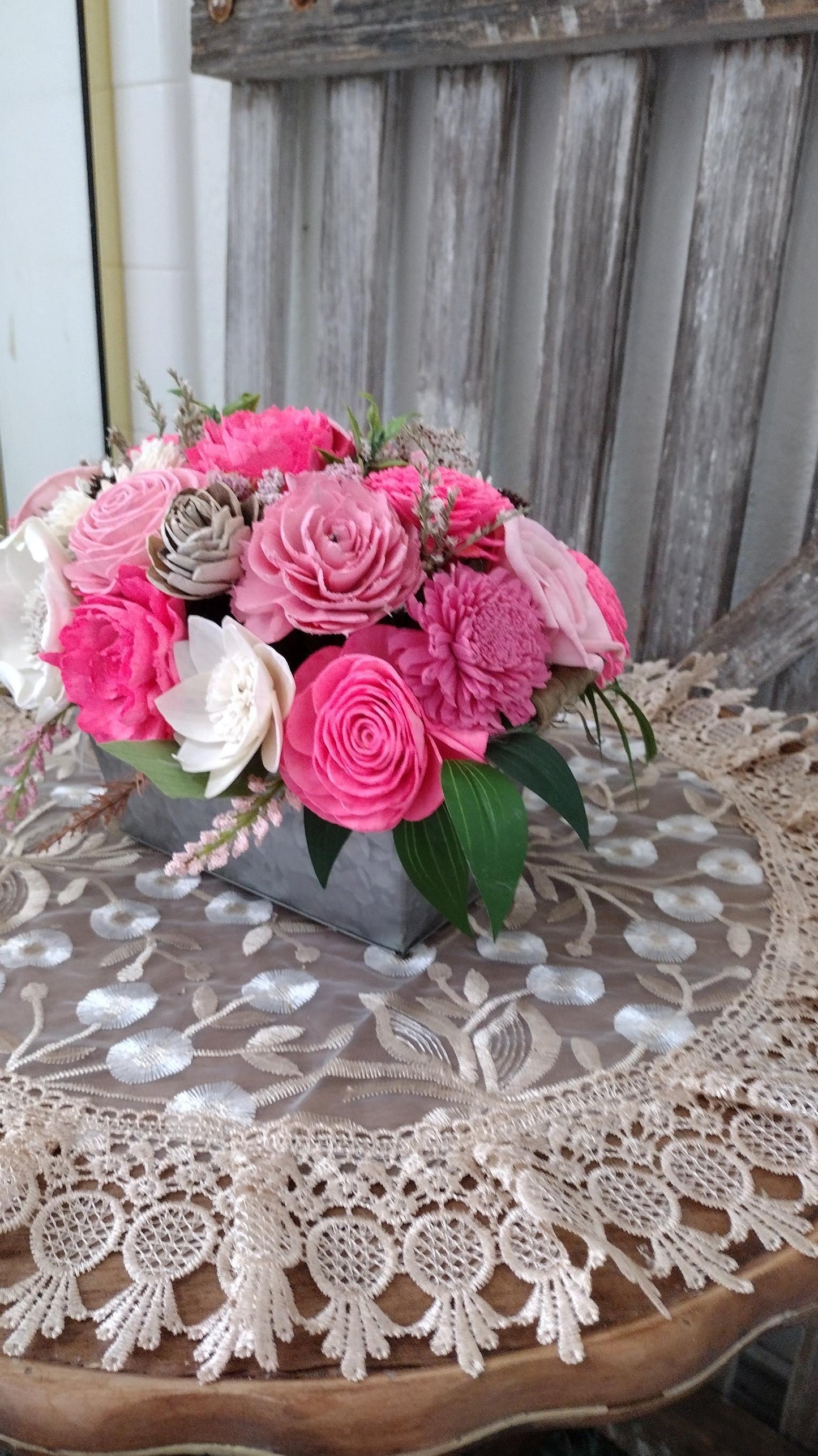 Centerpiece with hand dyed Sola flowers. Beautiful shades of pink wooden florals in a galvanized container