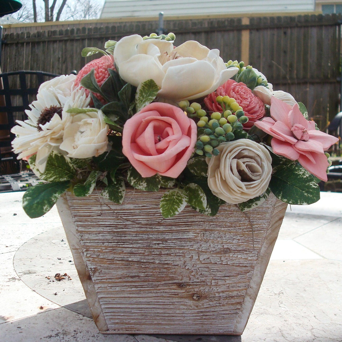 Pale pink in white Sola flowers in a washed wood planter